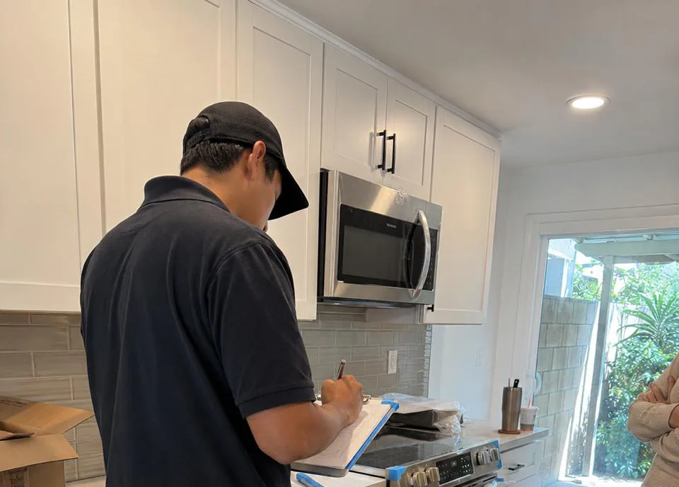 Owner-operated appliance repair technician servicing a refrigerator in a Tustin, California kitchen near Old Town and Tustin Ranch
